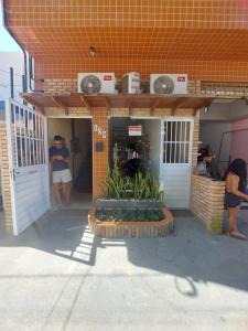 a woman standing in the doorway of a building at Mini suíte Atitude Maragogi Centro in Maragogi