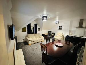 a living room with a dining table and a kitchen at 1 Luxe Exec Bedroom Apt Derby in Derby