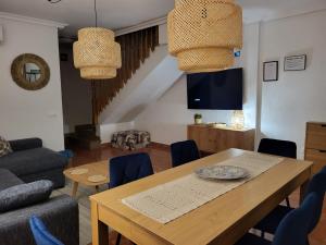 a living room with a wooden table and blue chairs at King`s Apartments in San Javier