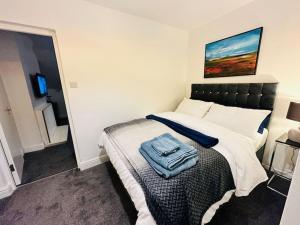 Un dormitorio con una cama con una toalla. en 1 Luxe Exec Bedroom Apt Derby, en Derby
