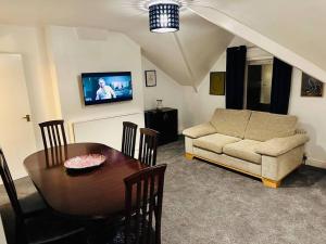 uma sala de estar com uma mesa e um sofá em 1 Luxe Exec Bedroom Apt Derby em Derby