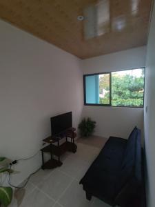 a living room with a couch and a table and a window at Apartamento la paz N°2 in Liberia