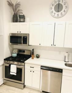 a kitchen with a stove and a clock on the wall at Superb 1BR Apartment in NYC! in New York