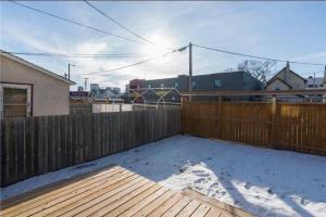 a wooden fence with snow on the ground at Sleek 3 bedroom home close to Exchange W parking in Winnipeg