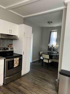 a kitchen with a stove and a table in it at Sleek 3 bedroom home close to Exchange W parking in Winnipeg