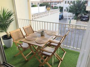 a wooden table and chairs on a balcony at Le Corail - Superbe Duplex 3 chambres 6 personnes in Le Grau-du-Roi