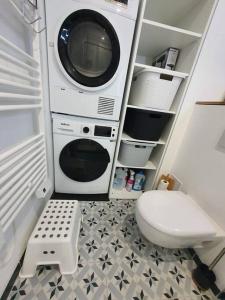 a bathroom with a toilet and a microwave and a washing machine at Le Corail - Superbe Duplex 3 chambres 6 personnes in Le Grau-du-Roi