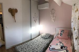 a small bedroom with a bed in a room at Le Corail - Superbe Duplex 3 chambres 6 personnes in Le Grau-du-Roi