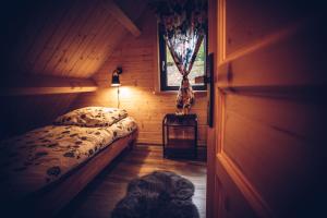 sypialnia z łóżkiem w drewnianym pokoju w obiekcie Łosiówka w mieście Bystre
