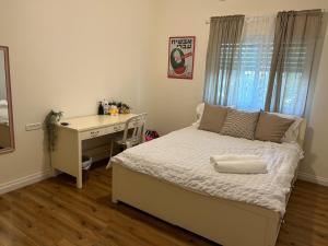 a bedroom with a desk and a bed and a bed and a desk at In the center of the Moshava in Zikhron Ya'akov