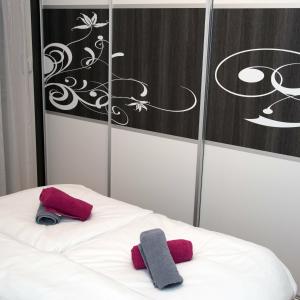 zwei Handtücher auf einem weißen Bett mit einem Gemälde in der Unterkunft City Osijek, CENTAR, SELF CHECK IN in Osijek