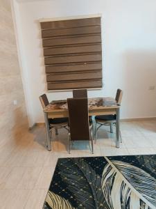 a table and chairs in a room with a rug at Traveler's house in Jerash