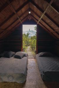 two beds in a room with a view of a mountain at Jardin del sol Ecoglamping in San José de Suaita