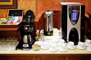 a counter with cups and plates and a coffee maker at Gold Apartments in Budapest +31 photos