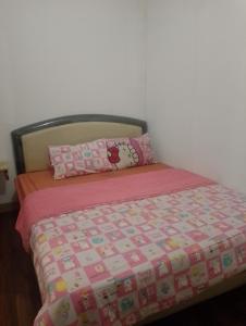 1 cama con manta rosa y 2 almohadas en Indah property en Cibubur