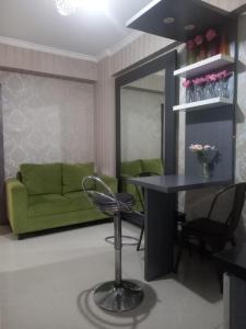 een woonkamer met een tafel en een groene bank bij Indah property in Cibubur