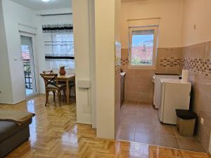 a kitchen and living room with a table and a couch at Dimos Apartman in Bijeljina
