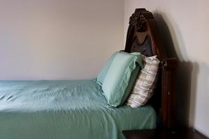 1 cama con cabecero y almohadas en Cozy East Haven Apartment - Walk to Beach!, en East Haven