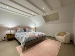um quarto com uma cama e uma cadeira em Chez Gaston - Entrelacs 
