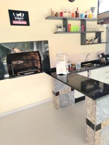 eine Küche mit einer schwarzen Arbeitsplatte in einem Zimmer in der Unterkunft Chácara Volare em Atibaia, exclusiva, condomínio fechado in Atibaia