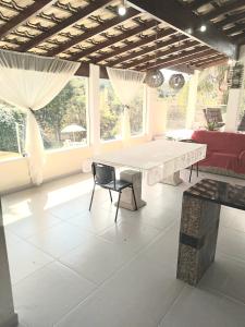 a living room with a table and a red couch at Chácara Volare em Atibaia, exclusiva, condomínio fechado in Atibaia