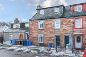 a brick house with blue trash cans in front of it at mySTAYINN Telford Guest House in Inverness