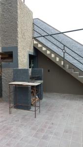 une terrasse avec une table à côté d'un escalier dans l'établissement HOSTAL HOUSE REYMON,habitaciones privadas" precio por persona", à Mendoza