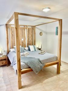 1 cama con marco de madera en una habitación en Triplex Caleta de Fuste Impresionantes vistas, en Caleta de Fuste