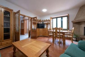 Una sala de estar con una mesa y un comedor. en Casa rural de uso turístico Playa de Carnota, en Canedó