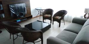 a living room with a couch and chairs and a table at Apartamento Confortável em Capão in Capão da Canoa
