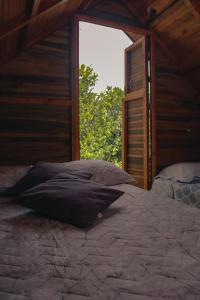 Cama en habitación con ventana abierta en Jardin del sol Ecoglamping, en San José de Suaita