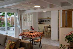 a living room with a table and a kitchen at La Maison de Paofai in Papeete