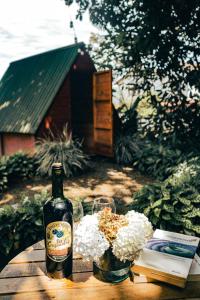 una botella de vino sentada en una mesa con flores en Jardin del sol Ecoglamping, en San José de Suaita