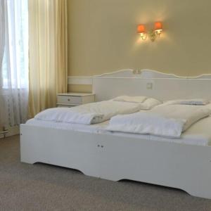 a bedroom with two beds with white sheets at Fiume Hotel in Békéscsaba