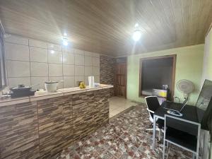 a room with a kitchen with a desk and a tv at Arenal Family House in Fortuna