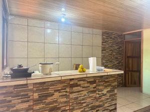 a kitchen with a counter with some fruit on it at Arenal Family House in Fortuna