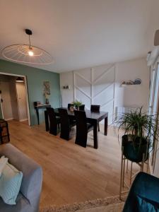 a living room with a table and black chairs at Maison spacieuse 8 pers 4 ch A31 EV in Rolampont +11 photos