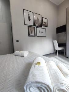 a white bedroom with a bed with towels on it at Vista sull'Eremo in Naples