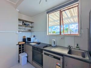 eine kleine Küche mit einem Waschbecken und einem Fenster in der Unterkunft 4 Bedrooms Escape, close to CBD in Rotorua