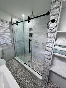 y baño con ducha y puerta de cristal. en Cozy East Haven Apartment - Walk to Beach!, en East Haven