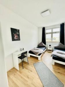 Dieses weiße Zimmer verfügt über 2 Betten und einen Schreibtisch. in der Unterkunft City Wohnung Zentral 85-5 in Dortmund