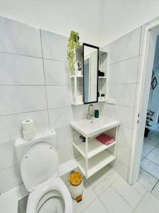 ein weißes Bad mit einem WC und einem Waschbecken in der Unterkunft City Wohnung Zentral 85-5 in Dortmund