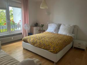 um quarto com uma cama com um cobertor amarelo em Feel home em Frankfurt am Main