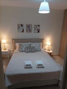 een slaapkamer met een bed met twee handdoeken erop bij Happy holiday apartment in Artemida