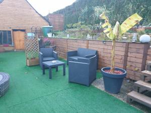 a patio with two chairs and a potted plant at Le Mouton Gras in Aumale