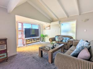 a living room with two couches and a tv at 4 Bedrooms Escape, close to CBD in Rotorua