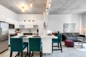 eine Küche mit einer großen weißen Insel mit grünen Stühlen in der Unterkunft Super convenient 1br apartment in Downtown 4 p 1708 in Miami