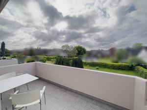 a white balcony with a table and chairs and a view at Ruhiges Juwel: frisch renoviert 100 qm in Jülich