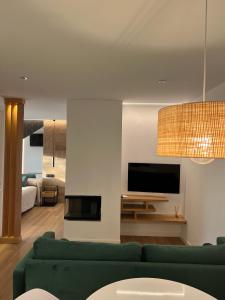 a living room with a green couch and a tv at Loft luxury Mirador in Cádiz