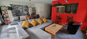 ein Wohnzimmer mit einem grauen Sofa und gelben Kissen in der Unterkunft Appartement avec terrasse in Sion